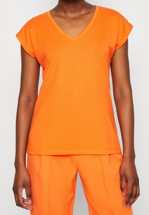 Orange V-hals t-shirt med kasketærmer, lavet af glat stof. Kanten er lige og passer til matchende orange bukser.