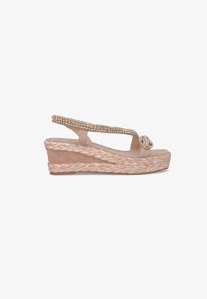Sandalia de cuña en ante rosa claro con suela de yute trenzado. Presenta una cinta decorada con strass y un diseño de punta descubierta.