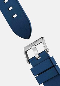 Granatowy silikonowy pasek do zegarka z metalową srebrną klamrą, posiadający wiele otworów do regulacji rozmiaru oraz gładką, matową fakturę.