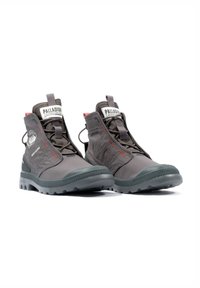 Bottes hautes grises avec une finition texturée, présentant des accents rouges, un patch logo et une semelle en caoutchouc durable pour une bonne adhérence.