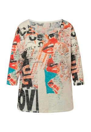 Chemise à manches 3/4 multicolore avec des graphiques de lèvres audacieux, des designs de texte, et un tissu léger avec une texture lisse. Encolure arrondie.