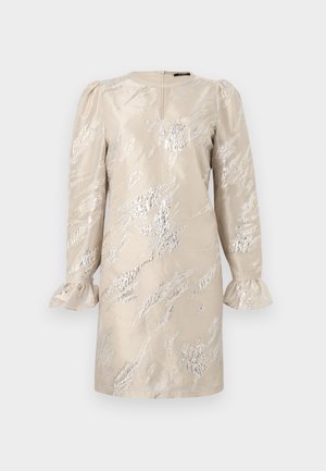 Beiges Kleid mit langen Ärmeln, texturiert mit silbernen Mustern. Hat einen runden Halsausschnitt und Rüschensäume. Schlitz im Rücken für ein einfaches Anziehen.