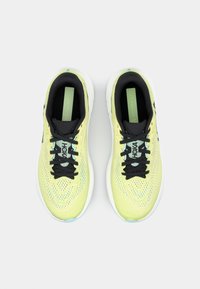 Gele sportschoenen met een bovenwerk van mesh, zwarte accenten, platte veters en een gevoerde kraag. Beschikt over een structuurzool en merkbranding op de tong.