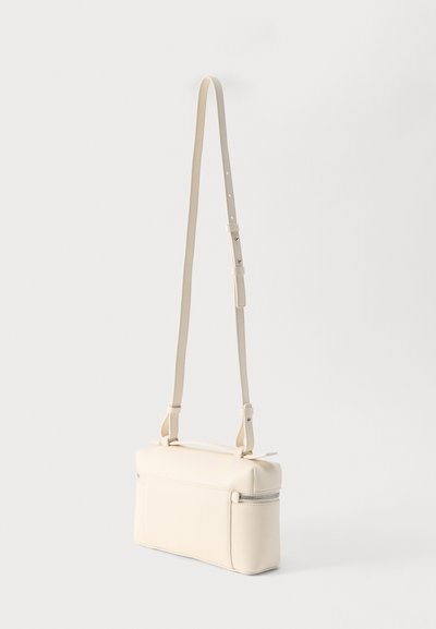 Μικρό ορθογώνιο τσάντα ώμου από κρέμ δέρμα με ρυθμιζόμενο λεπτό λουρί και φερμουάρ στο πάνω μέρος.