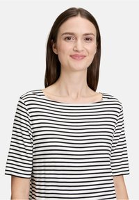 Stribet t-shirt i sort og hvid, med korte ærmer og firkantet halsudskæring, lavet af et blødt, let stof.