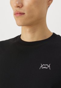 Puma JAWS CORE - Základné tričko - puma black
