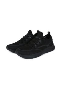 Baskets de sport noires avec une tige en maille texturée, fermeture à lacets et une semelle douce et rembourrée. Présente un tirant à l'arrière pour un enfilage facile.
