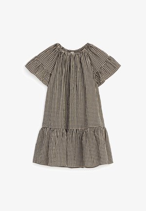 Schwarz-weiß kariertes Kurzarmkleid mit elastischem Ausschnitt und Rüschen-Details am Saum auf weißem Hintergrund.