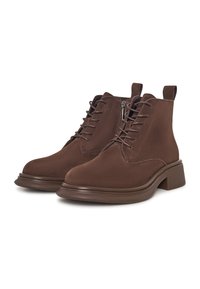 Un par de botas de tobillo de ante marrón con cordones, cremalleras laterales, tiradores y tacones bajos en un fondo blanco.
