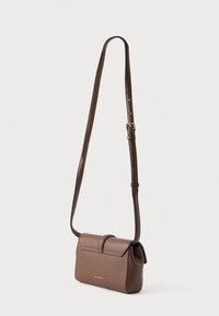 Liten brun lær crossover-veske med justerbar stropp og frontklafflås, "Karl Lagerfeld" preget i gullbokstaver.