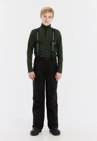 Groene fleece top met lange mouwen en een ritssluiting bij de kraag, gecombineerd met zwarte geïsoleerde broeken en zwarte laarzen. De broeken hebben verstelbare bretels.