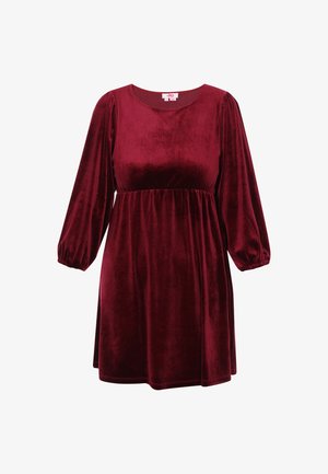Bordó bársonyruha kerek nyakkal, hosszú puffos ujjakkal és rakott derékkal, sima, puha textúrával és térd alá érő szoknyával.