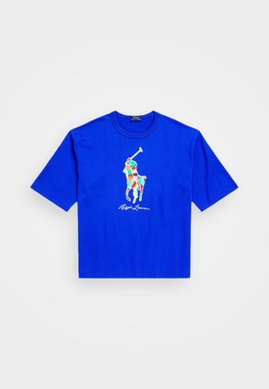 Jasnoniebieski t-shirt z krótkim rękawem i okrągłym dekoltem, z kolorową grafiką gracza polo i podpisem Ralph Lauren na środku przodu.
