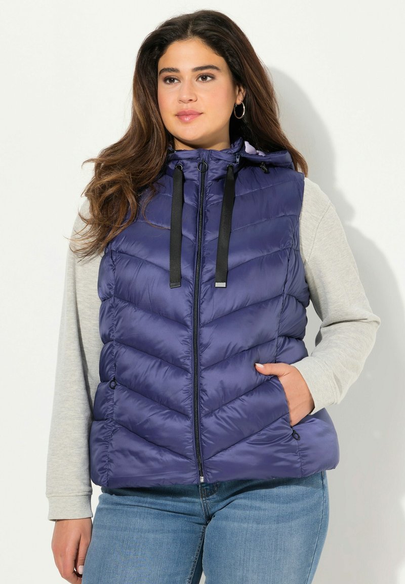 Granatowa kamizelka puchowa z wzorem w zygzaki, zipem z przodu oraz regulowanym kapturem ze sznurkiem. Lekki materiał z bocznymi kieszeniami.