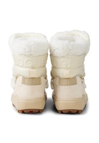Kremowe kozaki z futrzanym podszyciem, miękkim zamszowym materiałem, teksturowaną gumową podeszwą i akcentami z logo na pięcie.