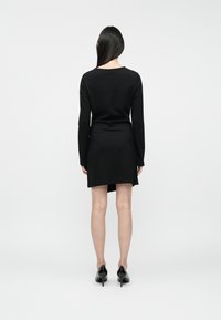 Must musträppariga must kleit, millel on keha kallutav bodice ja laienev seelik. Sile kangas, kuni reie keskosa pikkus ja peen kumer kaelus.