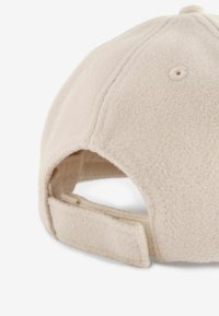 Beige kasket lavet af blødt, tekstureret stof med en buet skygge, et justerbart bånd bagpå og subtile syninger.