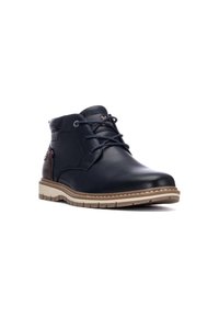 Botas de cuero negras hasta el tobillo con punta redondeada, diseño con cordones y suela beige en contraste. Presenta costuras sutiles y acentos laterales.