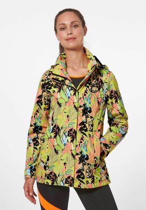 Veste colorée à motif floral en vert, rose et bleu avec une fermeture éclair, une capuche adjustable et un détail de logo sur le côté supérieur gauche.