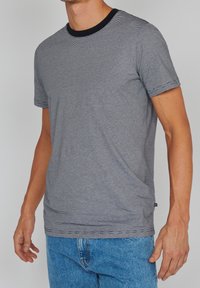 Grau gestreiftes T-Shirt mit schwarzem Rundhalsausschnitt, kurzen Ärmeln und lockerer Passform. Leicht strukturierter Stoff mit geradem Saum.