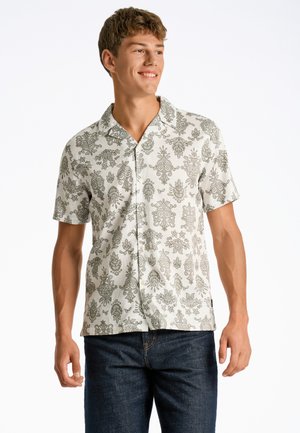Camisa de manga corta en color beige claro con intrincados patrones florales y de paisley en verde, que cuenta con un collar tipo botón y un corte relajado.