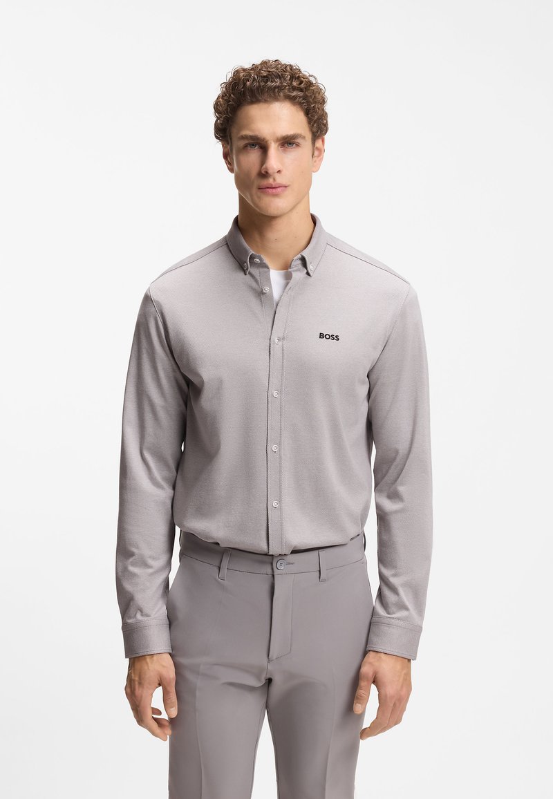 Ανοιχτό γκρι πουκάμισο με κουμπιά και μακριά μανίκια από υφασμάτινη υφή, με γιακά και μικρό μαύρο λογότυπο "BOSS" στο στήθος.