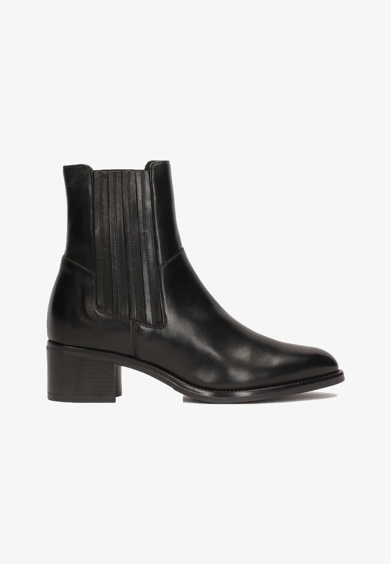 Bottine en cuir noir avec panneaux latéraux élastiques, bout pointu, petit talon bloc et coutures visibles sur fond blanc.