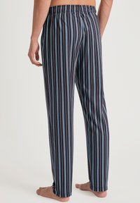 Gestreepte pyjamabroek in marineblauw, met verticale strepen in lichtblauw en wit. Elastische tailleband en lichte stof voor comfort.