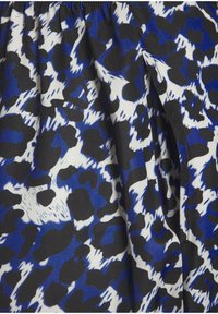 Sinine, must ja valge kangas, millel on julge loomaprintimise muster ning pehme tekstuur; koguneb talje ümber; kerge ja voolav disain.