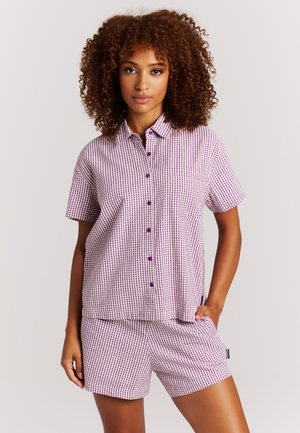 Lila-weiß kariertes Kurzarmhemd mit Knöpfen und Tasche, kombiniert mit passenden Shorts. Baumwollstoff, lockere Passform.