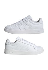 Par de zapatillas Adidas blancas de corte bajo con cierre de cordones y tres franjas laterales cosidas, mostradas de perfil sobre fondo blanco.