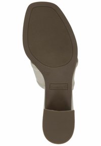 Tan shoe sole with textured grip, featuring a slight heel and embossed logo. Size 37 marked on the side. Smooth material with a matte finish.