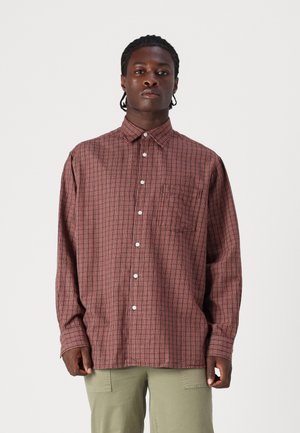 Red and navy plaid shirt with long sleeves, button-down collar, front pocket, and white buttons. Made from a lightweight fabric.