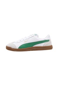 Zapatilla blanca con acentos verdes, punta en gamuza texturizada y suela de goma. Presenta un diseño deportivo y un sistema de cordones con el logotipo de la marca.