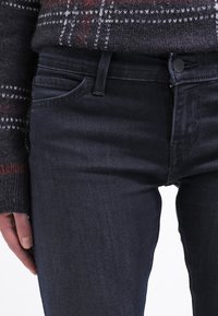 Mörka denimjeans med en slät yta, med en klassisk femfickdesign och en knäppning i midjan.