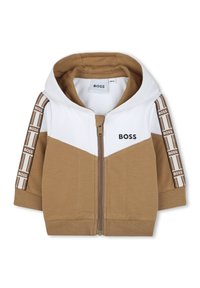 Sudadera con cremallera en marrón y blanco, con capucha. Presenta franjas de marca en las mangas, material de algodón y un diseño de bloques de color diagonal.