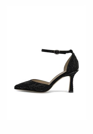 Décolleté nera in suede con tacco alto, punta affusolata, cinturino alla caviglia e dettagli di perline sulla parte superiore. Presenta un tacco sottile e un design testurizzato.