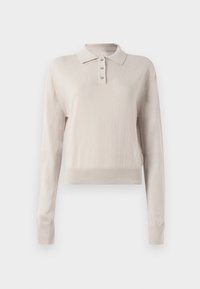 Polo-shirt à manches longues beige clair. Tissu doux avec une texture en tricot, doté d'un col classique et d'une patte de boutonnage à trois boutons. Design court.
