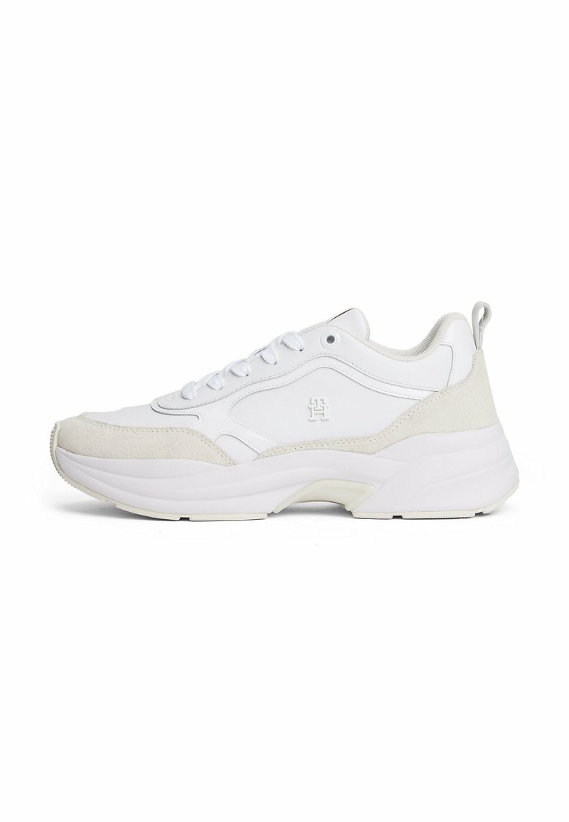 Białe sneakersy wykonane z materiałów skórzanych i zamszowych, z masywną podeszwą, okrągłym noskiem, sznurowanym przodem oraz teksturowymi akcentami po bokach.