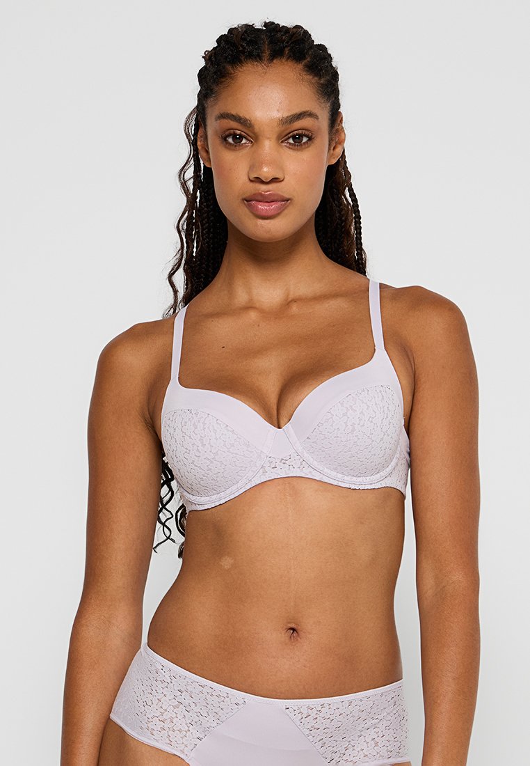 Jasnoliliowy biustonosz z koronkowymi detalami, wsparcie z fiszbinami, regulowane ramiączka oraz pasujące koronkowe majtki w podobnym kolorze, gładka tekstura.