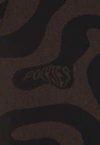 Tissu marron à motifs présentant des tourbillons abstraits ; comprend un texte subtil "POCKETS" intégré dans le design. Texture douce.