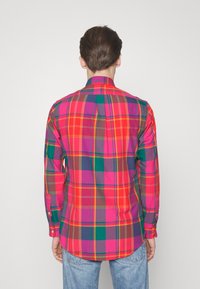 Koszula z długim rękawem, zapinana na guziki, z wielokolorowym wzorem w kratę w odcieniach różu, zieleni, pomarańczu i fioletu, z zaokrąglonym dołem i dopasowanym fasonem.