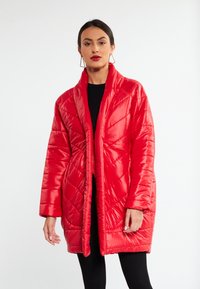 Rød, quiltet pufferjakke med sjalkrave og lange ærmer; glat stof med et chevron-mønster; åben frontdesign.