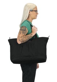 Grote zwarte tote bag gemaakt van duurzaam stof met twee stevige handvatten, gekenmerkt door een geplooide ontwerp aan de voorkant en een ruime binnenkant.