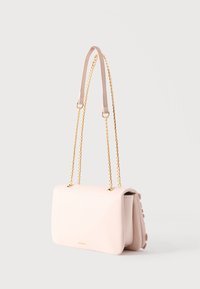 Bolso de piel rosa claro con asa de cadena dorada y pequeño logo dorado en el frente, mostrado sobre un fondo blanco liso.