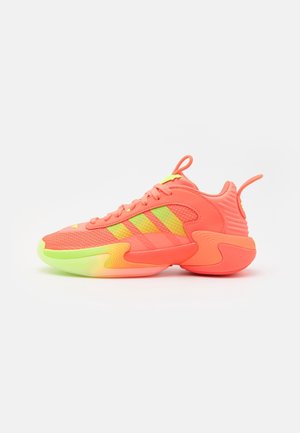 Neon růžová sportovní obuv s síťovaným svrškem, se třemi žlutými pruhy, polstrovaným límcem a vícebarevnou gumovou podrážkou přecházející do zelené.