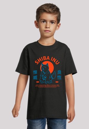 Schwarzes T-Shirt mit einem Shiba Inu Grafik in Blau und Orange, mit japanischem Text darunter, präsentiert an einem Kind in lässigen Jeans.