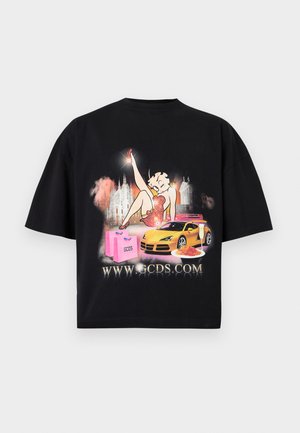 Black t-shirt with cartoon woman in red dress, yellow sports car, pink shopping bags, plate of pasta, champagne glass, and website URL.