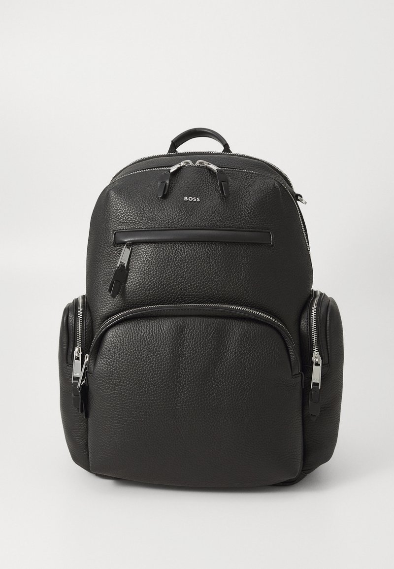 Black leather backpack with a textured finish, dual front zip pockets, and a top handle; features a logo and silver hardware accents.