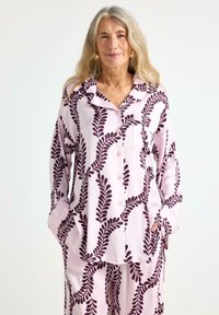 Lyserød pyjamas sæt med mønster og bladdesign i mørk lilla, med lange ærmer, krave og lomme detaljer.